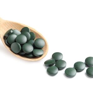 Spirulina Tabletten Pressling auf einem Holzlöffel