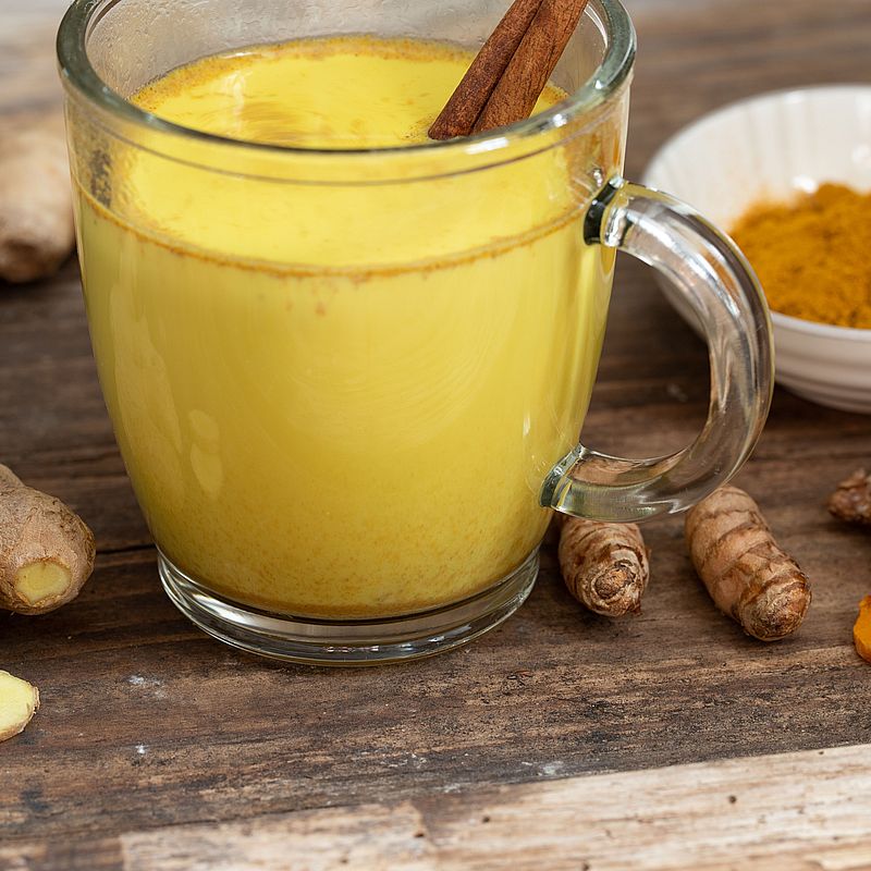 Goldene Milch in einem Glas mit Kurkuma, Zimt und Ingwer